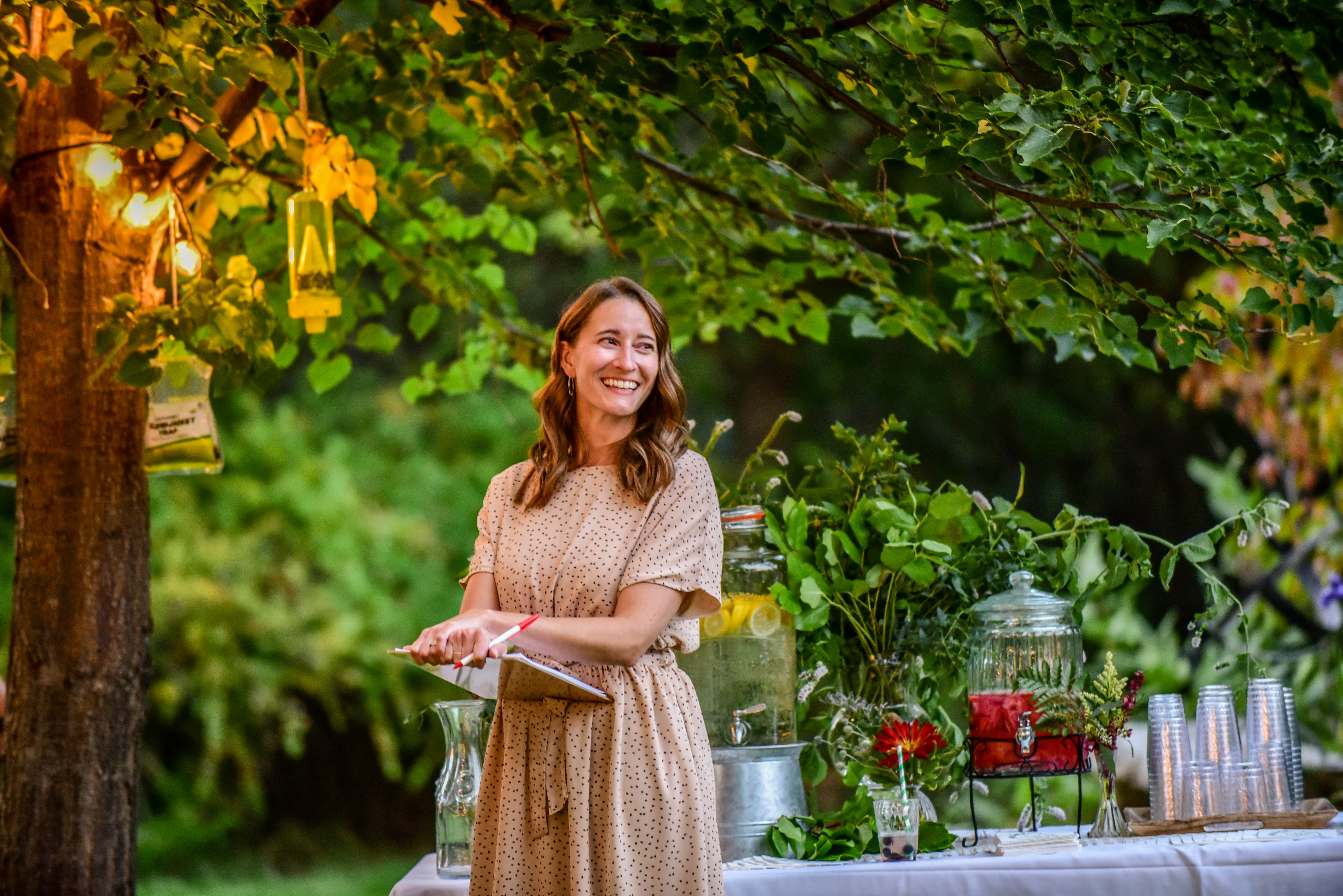 Event host beneath lantern-lit trees at Support Our Girls